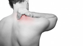 shoulder pain treatment. man holding this shoulder, gripping it as he is in pain