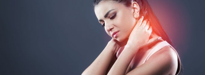 A lady holding her neck as she looks in pain. She is grasping her neck with two hands. The pain is highlighted with red on the area